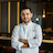 professional portrait of a head chef in white uniform with a confident smile in a modern restaurant kitchen setting
