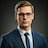 headshot of a young male operations manager with spectacles looking professional and focused